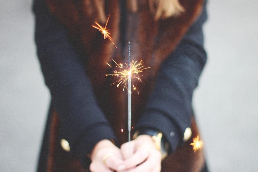 faceless woman holding a sparkler to depict inspiration