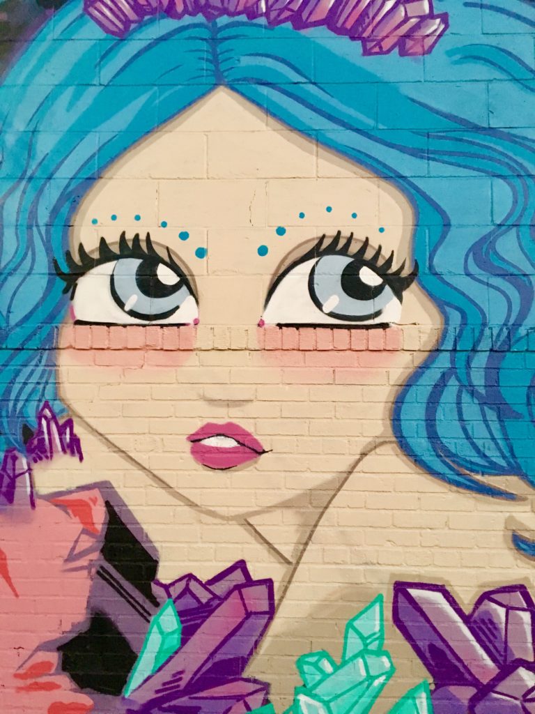 Street art of a woman with blue hair in Bushwick
