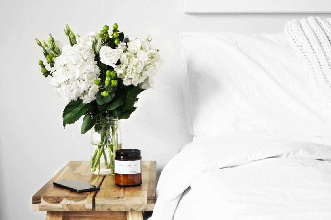 bright and airy bedroom bliss with white walls and rustic nightstand