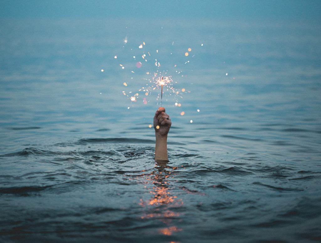 if you're feeling down, there's always a silver lining as this picture of a hand emerging from water with a sparkler shows