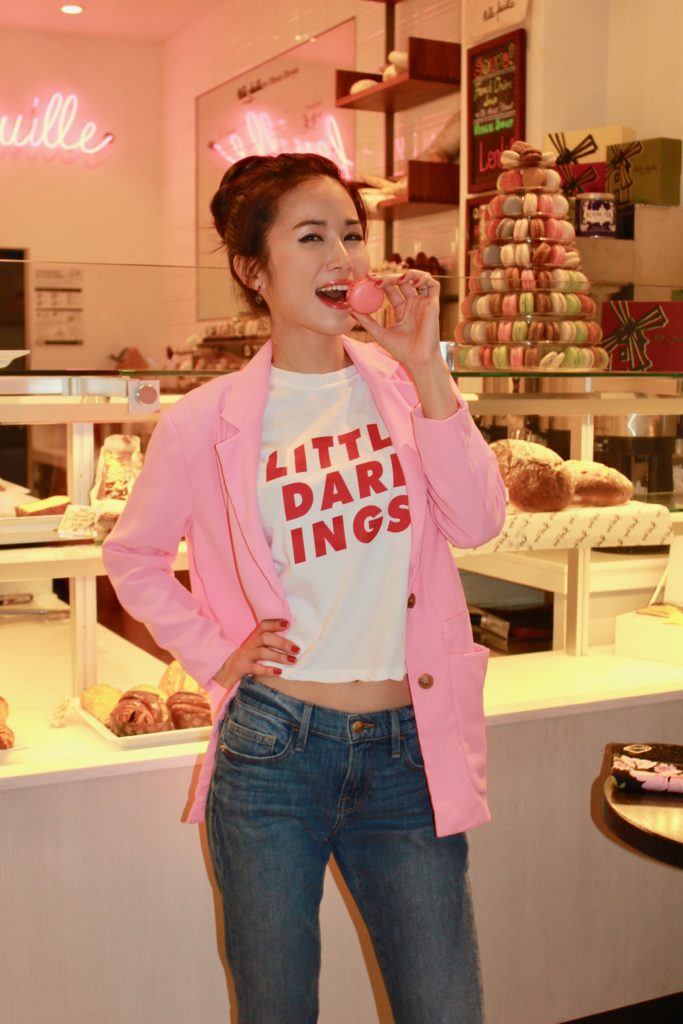 Jinhye in a pink blazer eats a pink macaron