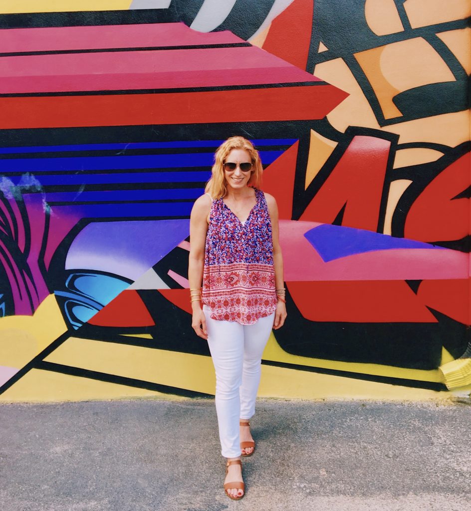 Merry Lerner in front of a mural at Wynwood Walls