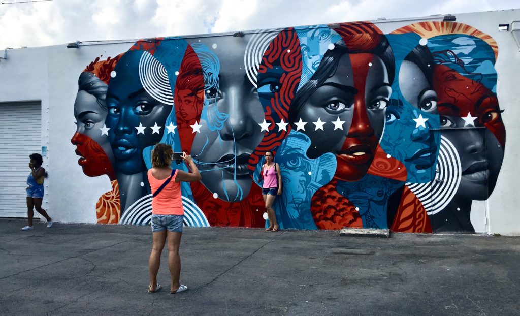 Tourists posing in front of a mural at Wynwood Walls in downtown Miami