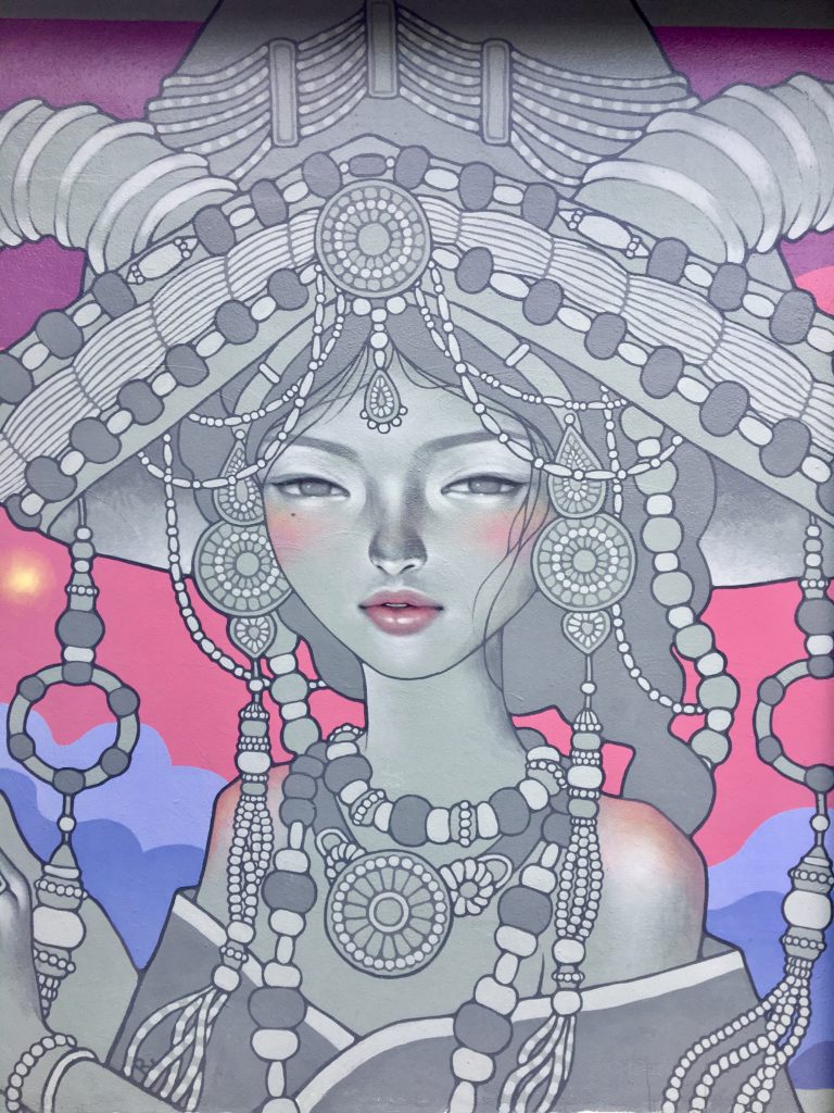 a beautiful mural of a woman in an elaborate headdress at wynwood walls