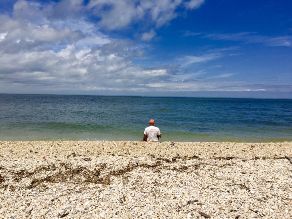 My husband enjoying a pebbly beach on the Long Island Sound on the North Fork of Long Island