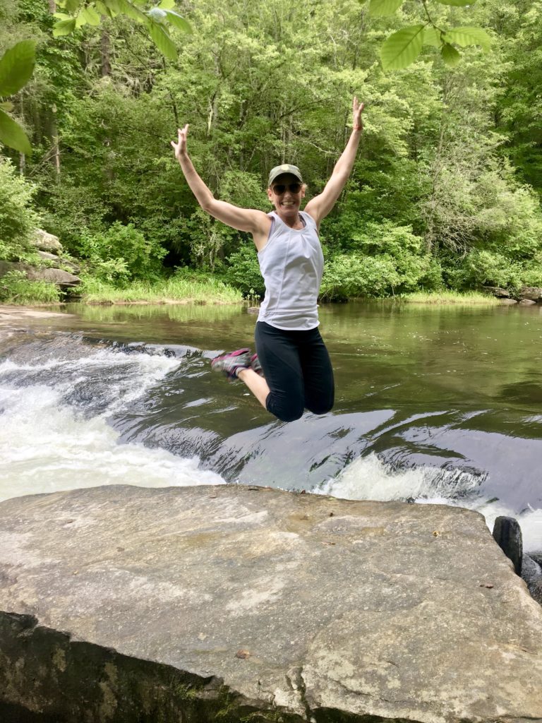Merry Lerner jumping for joy during a hike in Asheville, North Carolina