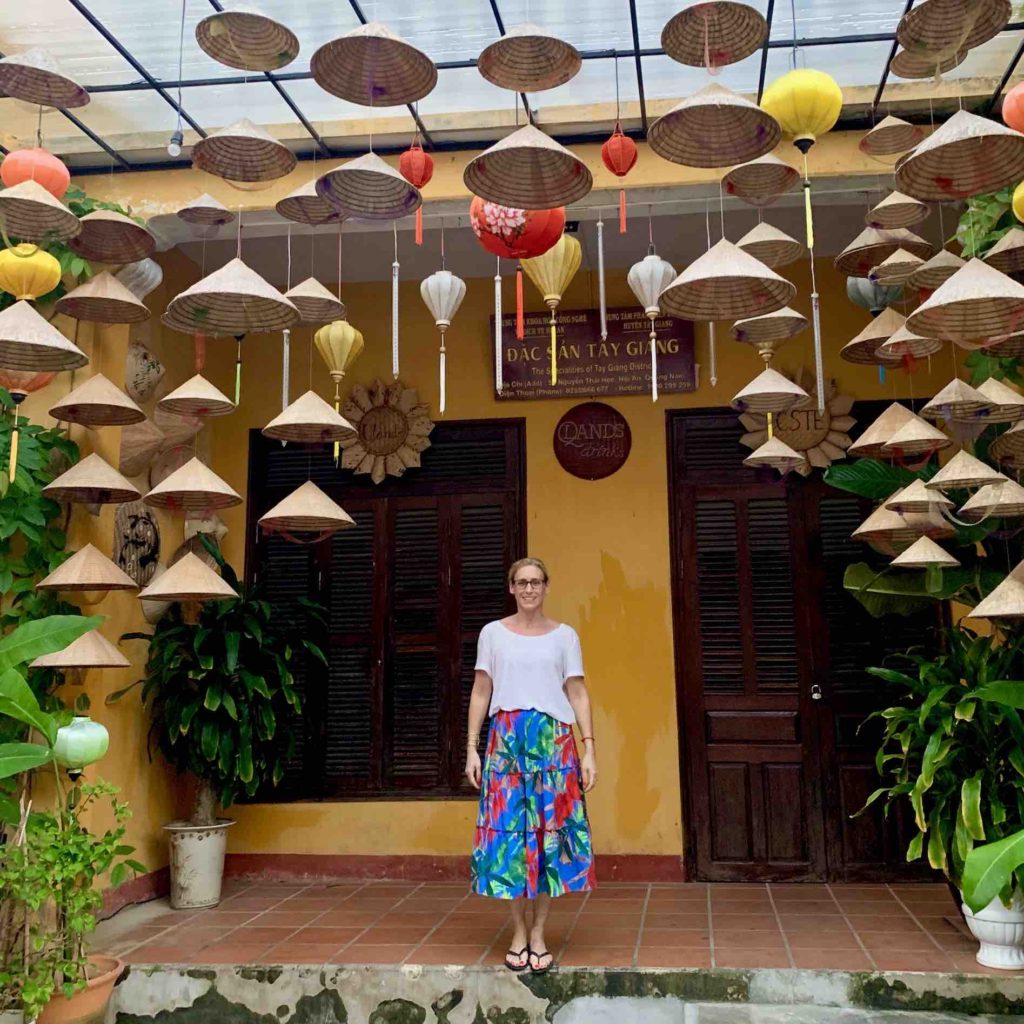 merry-posing-among-basket-weave-hats-in-hoi-an-vietnam
