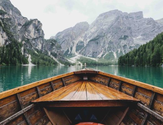 travel-trends-in-2021-outdoor-vacations-in-nature-canoe-on-green-lake-surrounded-by-mountains